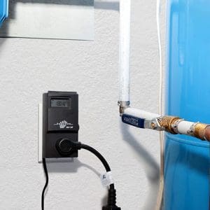 Thermostat and timer plugged into outlet on wall inside