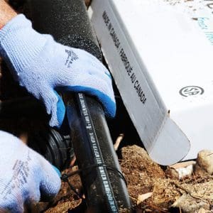 Contractor installing external self-regulating heat trace system to pipe outdoors