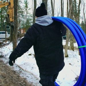 Contractor carrying water line freeze protection system over shoulder to job site